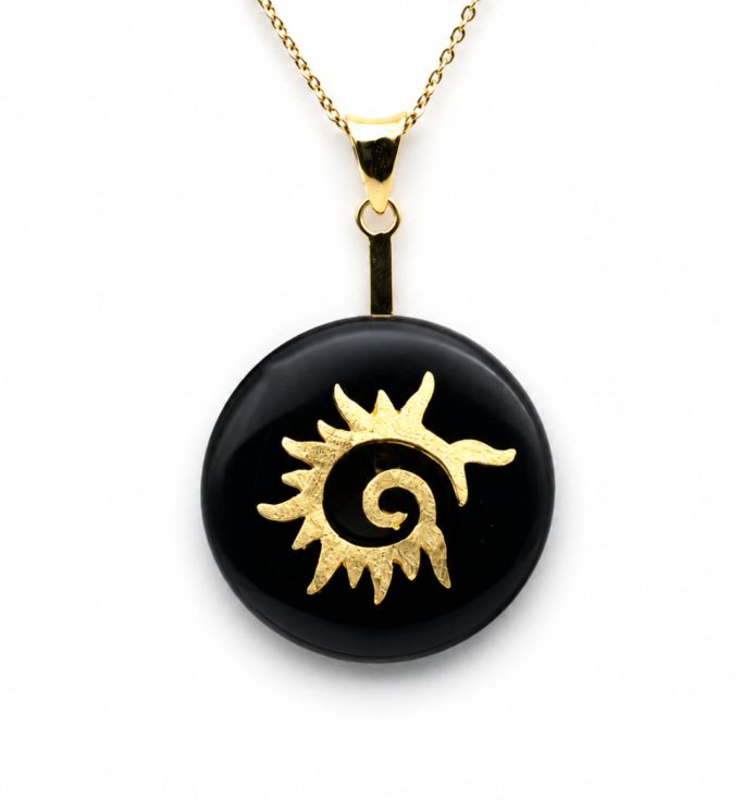 Schwarzer Obsidian Donut in einer goldenen Flammenspirale gehalten an goldener Kette auf weißem Hintergrund.