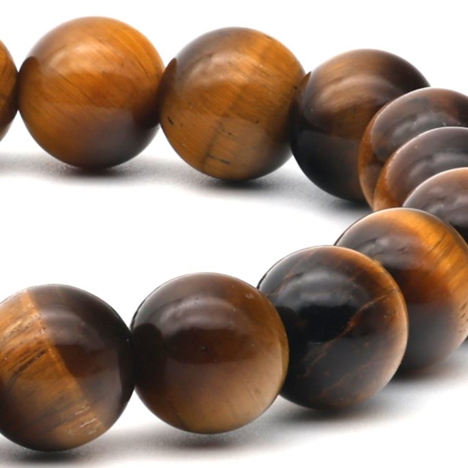 Teil eines Tigerauge Armbandes auf weißem Hintergrund.